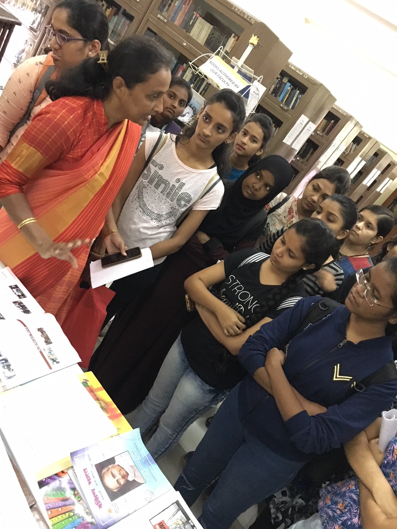 Students with teacher at the book display in the library