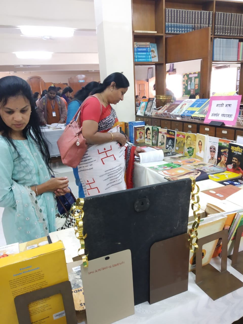 Visitors Dr. Mahalaxmi Morale (Jedhe College) and Supriya Shelar inspecting books